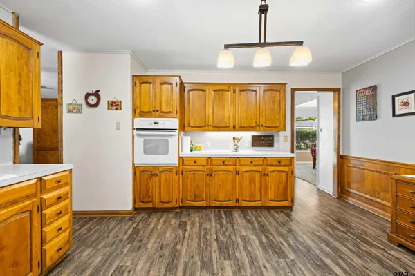 a large kitchen with stainless steel appliances granite countertop a stove and a wooden floors