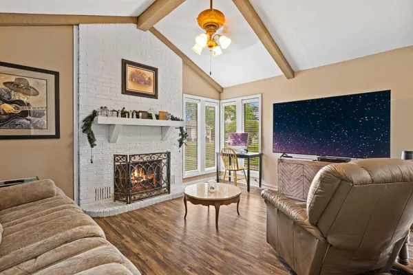 a living room with furniture a flat screen tv and a fireplace