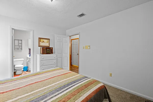 a bedroom with a bed and a large mirror