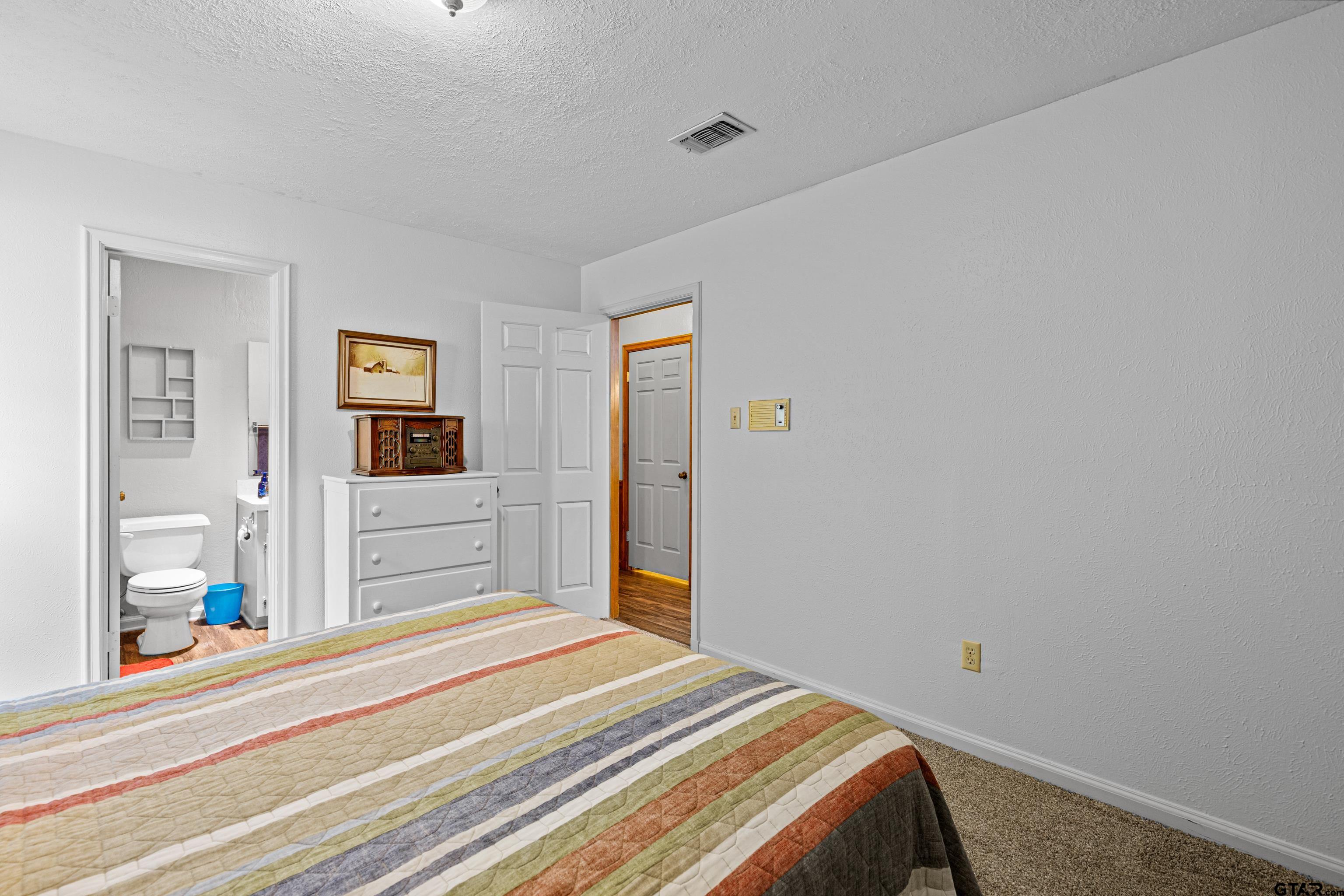 1810 Azalea Street Gilmer, TX 75644 - Photo 32 of 47 a bedroom with a bed and a large mirror