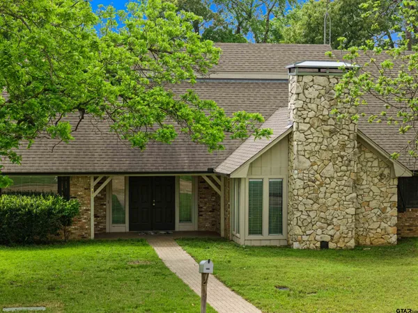 a front view of a house with a garden and yard