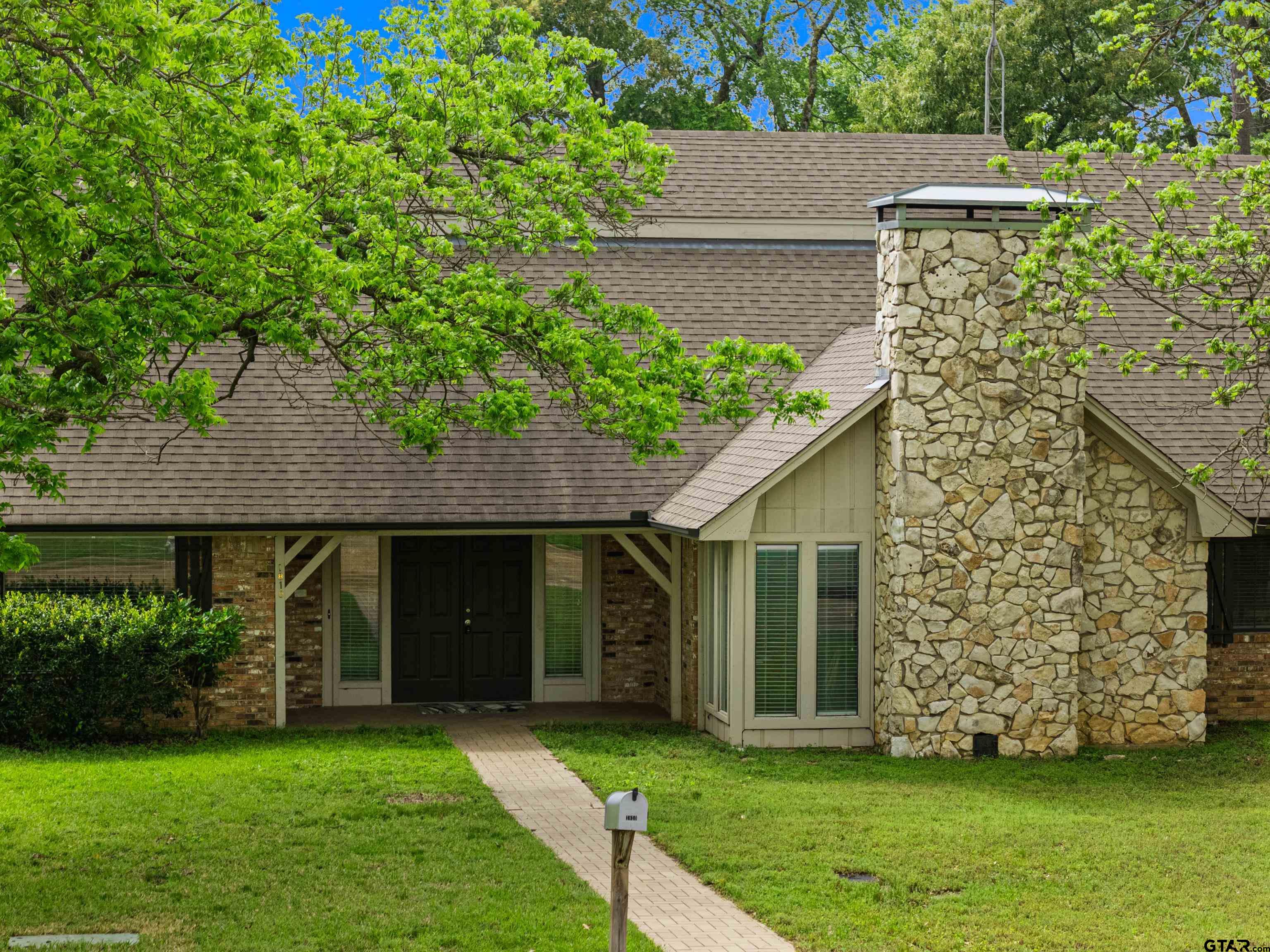 1810 Azalea Street Gilmer, TX 75644 - Photo 4 of 47 a front view of a house with a garden and yard