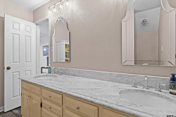 a bathroom with a granite countertop double vanity sink and mirror