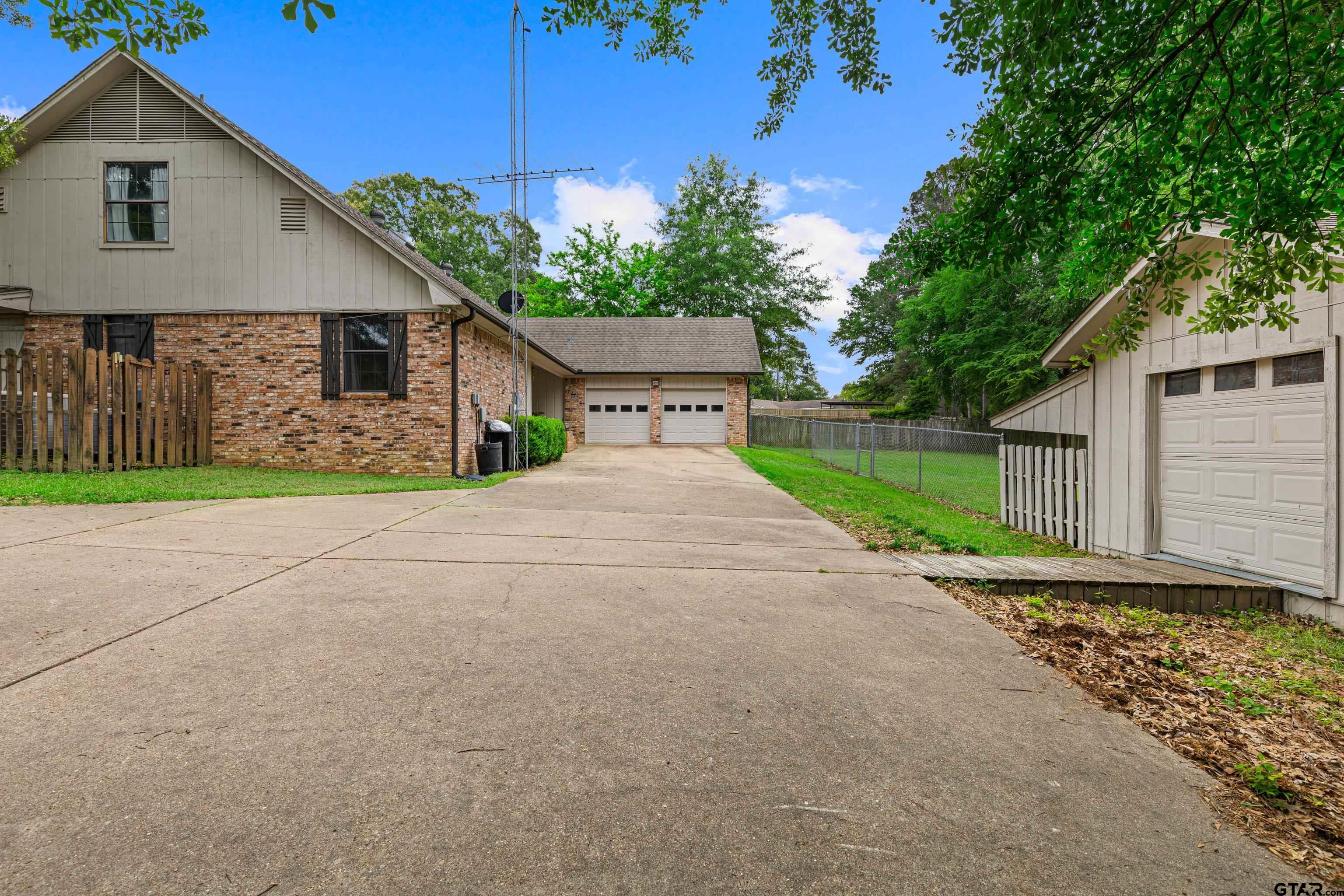 1810 Azalea Street Gilmer, TX 75644 - Photo 46 of 47 a front view of a house with a yard and garage