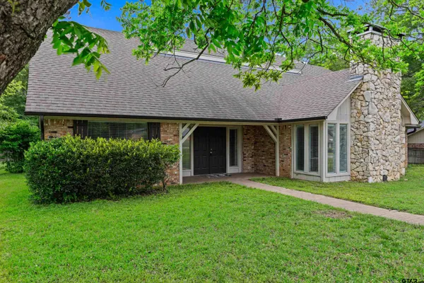 a front view of a house with a garden and yard