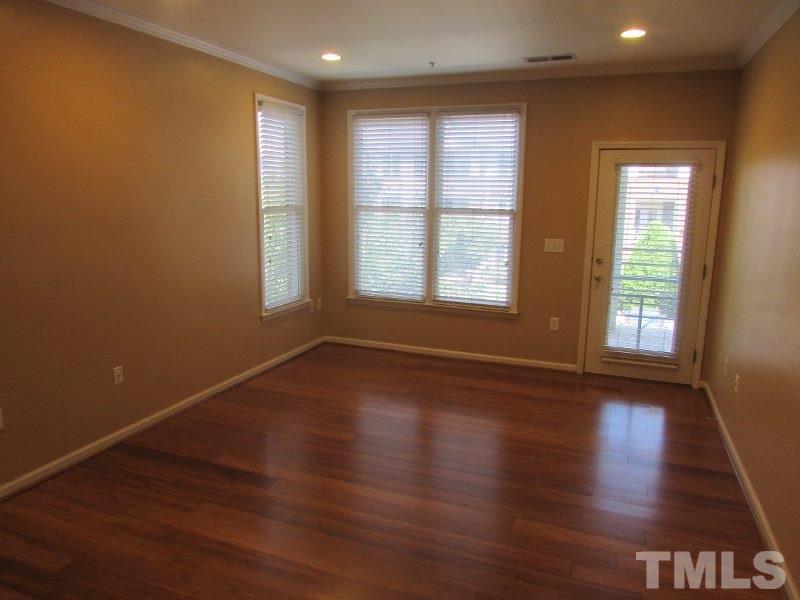 710 North Person Street, Unit 207 Raleigh, NC 27604 - Photo 3 of 12 an empty room with wooden floor and windows