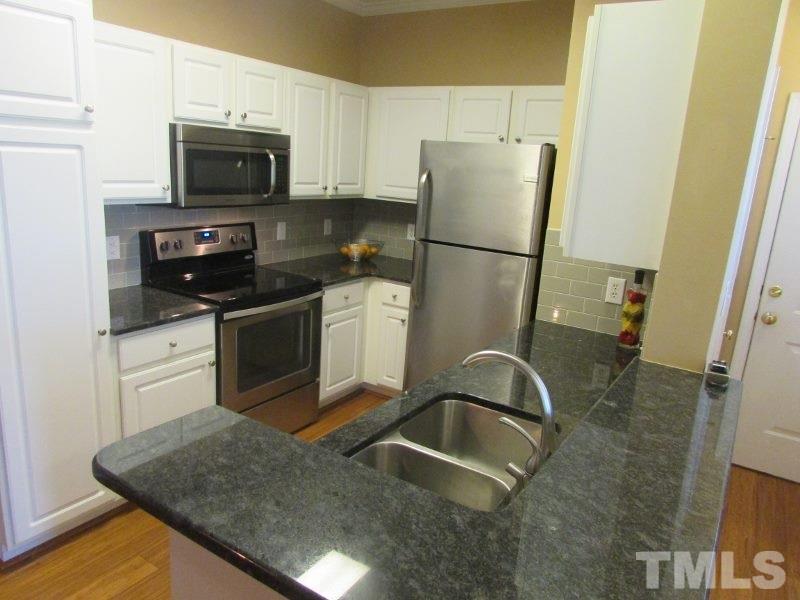 710 North Person Street, Unit 207 Raleigh, NC 27604 - Photo 6 of 12 a kitchen with granite countertop a refrigerator stove and sink