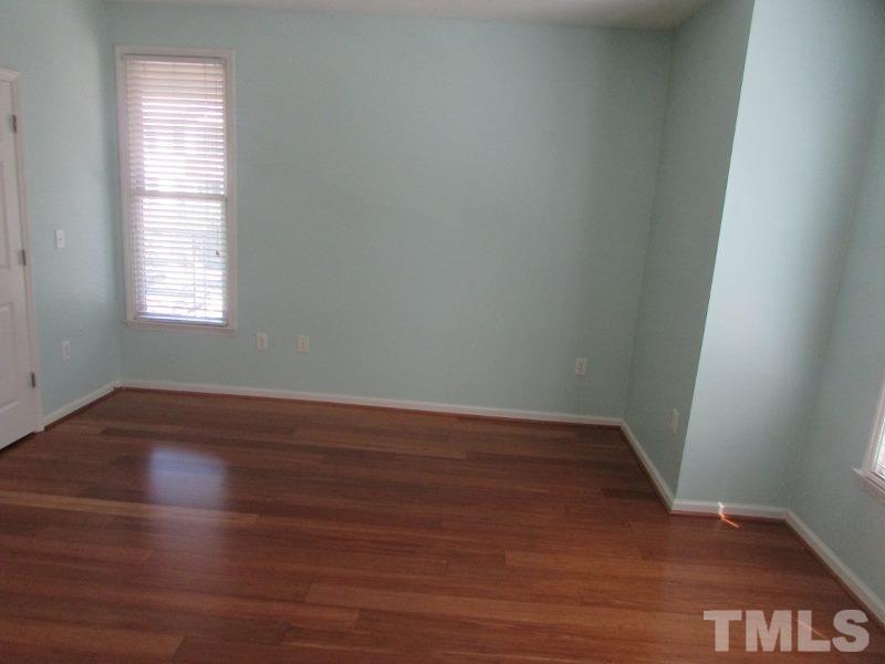 710 North Person Street, Unit 207 Raleigh, NC 27604 - Photo 10 of 12 an empty room with wooden floor and windows