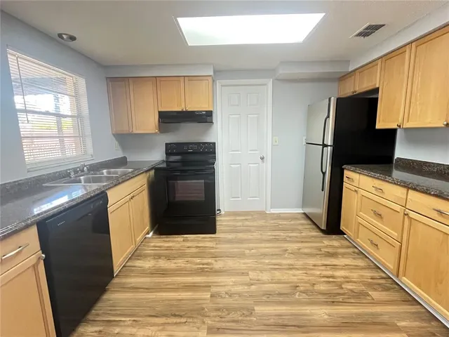 a kitchen with stainless steel appliances granite countertop a stove a sink and a refrigerator