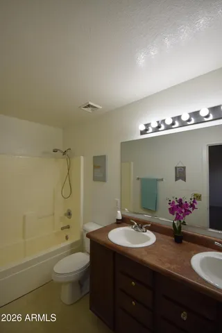 a bathroom with a granite countertop sink mirror toilet and bathtub