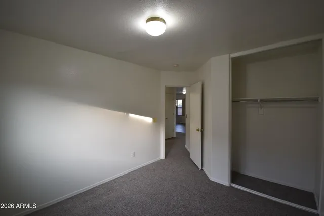 an empty room with closet and mirror