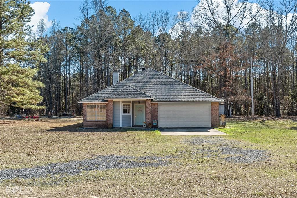 136 Scarborough Road Benton, LA 71006 - Photo 6 of 32 Brick and siding exterior featuring a covered entry, attached garage, and a gravel driveway