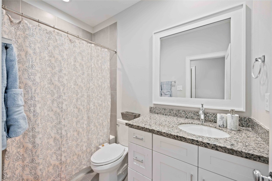 1324 West Pierce Street Houston, TX 77019 - Photo 21 of 26 a bathroom with a granite countertop sink a toilet and a mirror