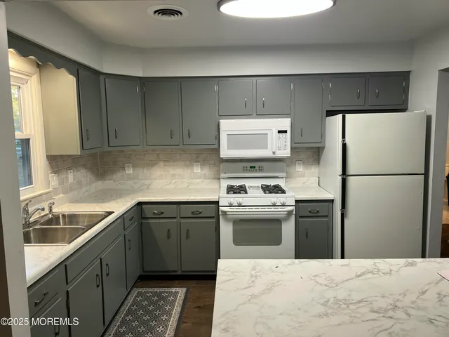 a kitchen with stainless steel appliances granite countertop a refrigerator sink and stove