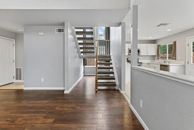 a view of a kitchen with wooden floor and electronic appliances