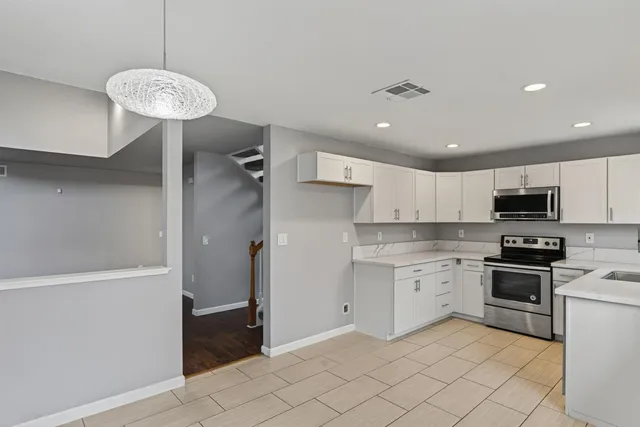 a kitchen with a refrigerator a sink and a stove top oven