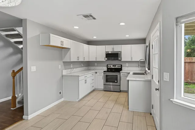 a kitchen with granite countertop appliances cabinets and a sink