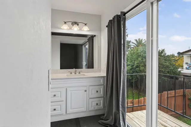 a bathroom with a granite countertop sink and a large mirror