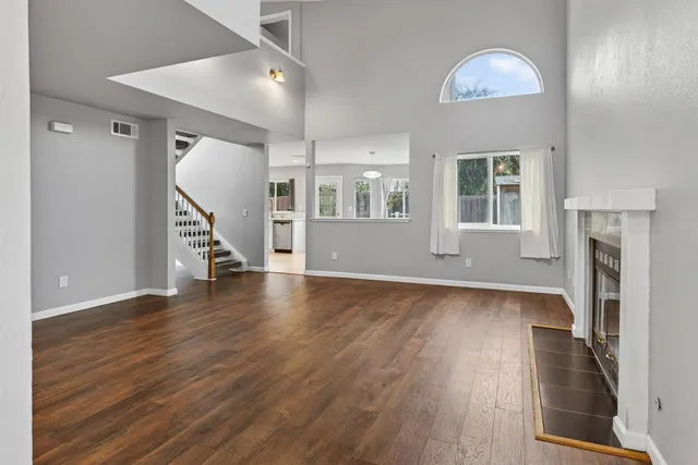 an empty room with wooden floor and a fireplace