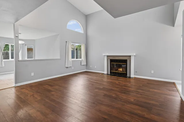 an empty room with wooden floor and a fireplace