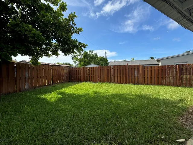 a view of a backyard with wooden fence