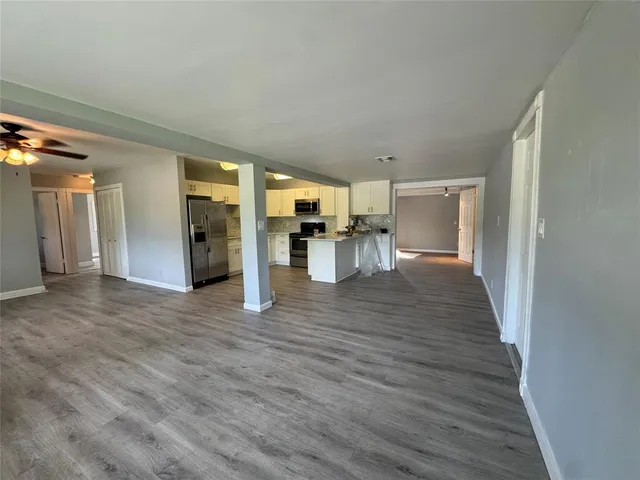 a view of empty room with wooden floor