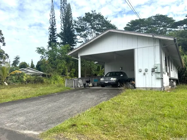 a view of a house with backyard and trees