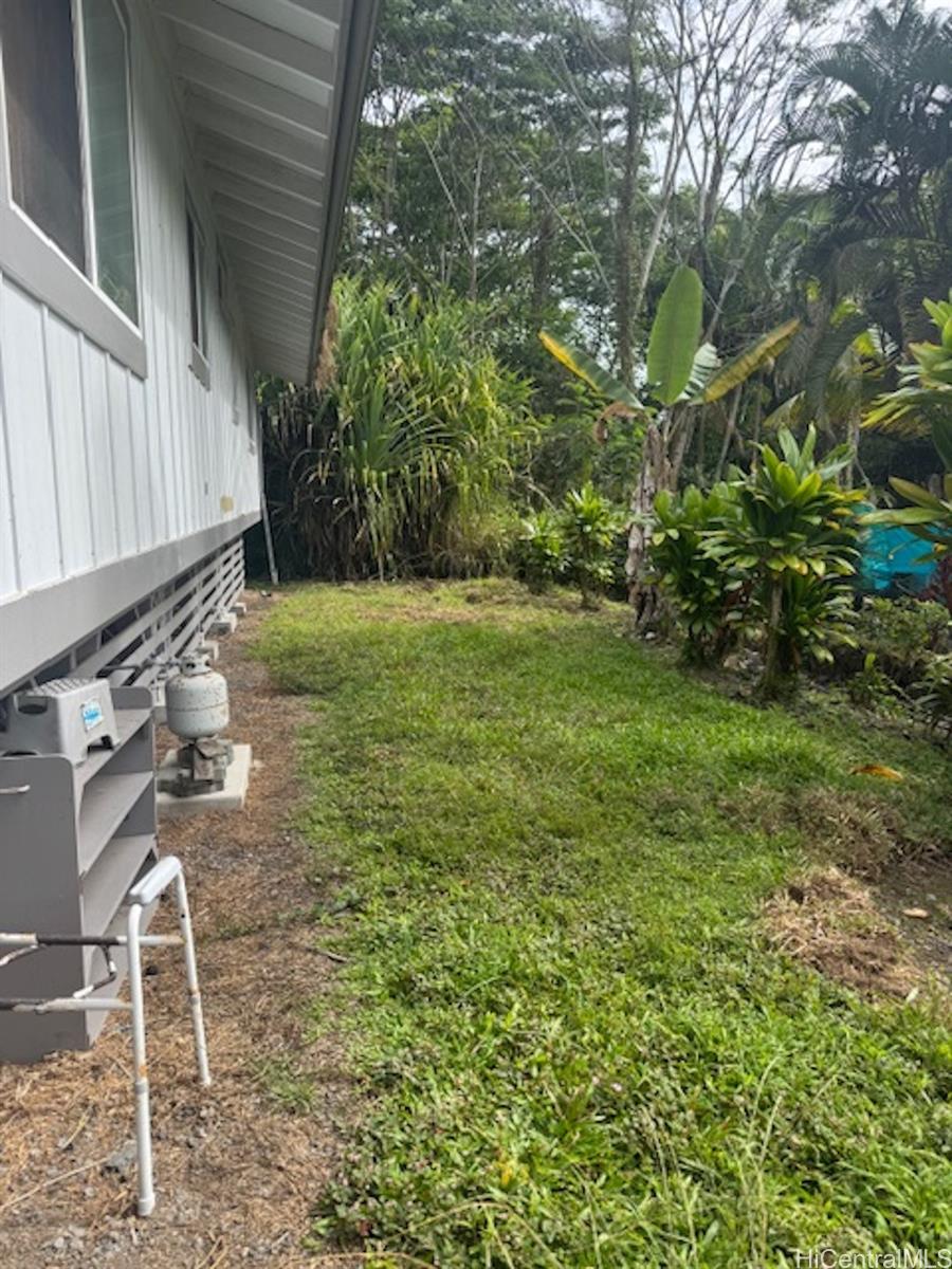 101 Kilua Road Hilo, HI 96720 - Photo 6 of 7 a backyard of a house with table and chairs