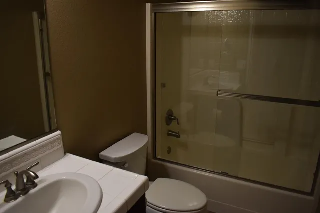a white toilet sitting next to a bathroom sink