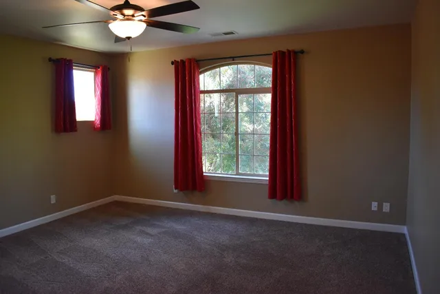 a view of a livingroom with a ceiling fan and window