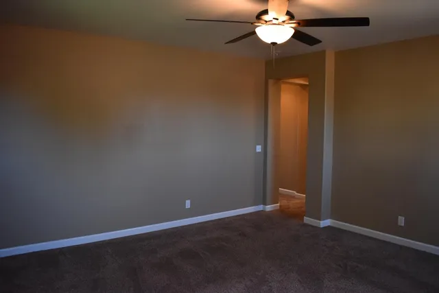 a view of a chandelier fan and hardwood floor