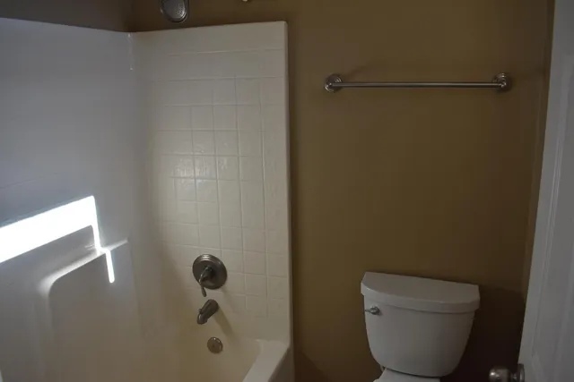 a bathroom with a toilet and a shower