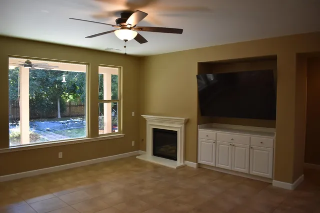 a view of an empty room with a fireplace and a window