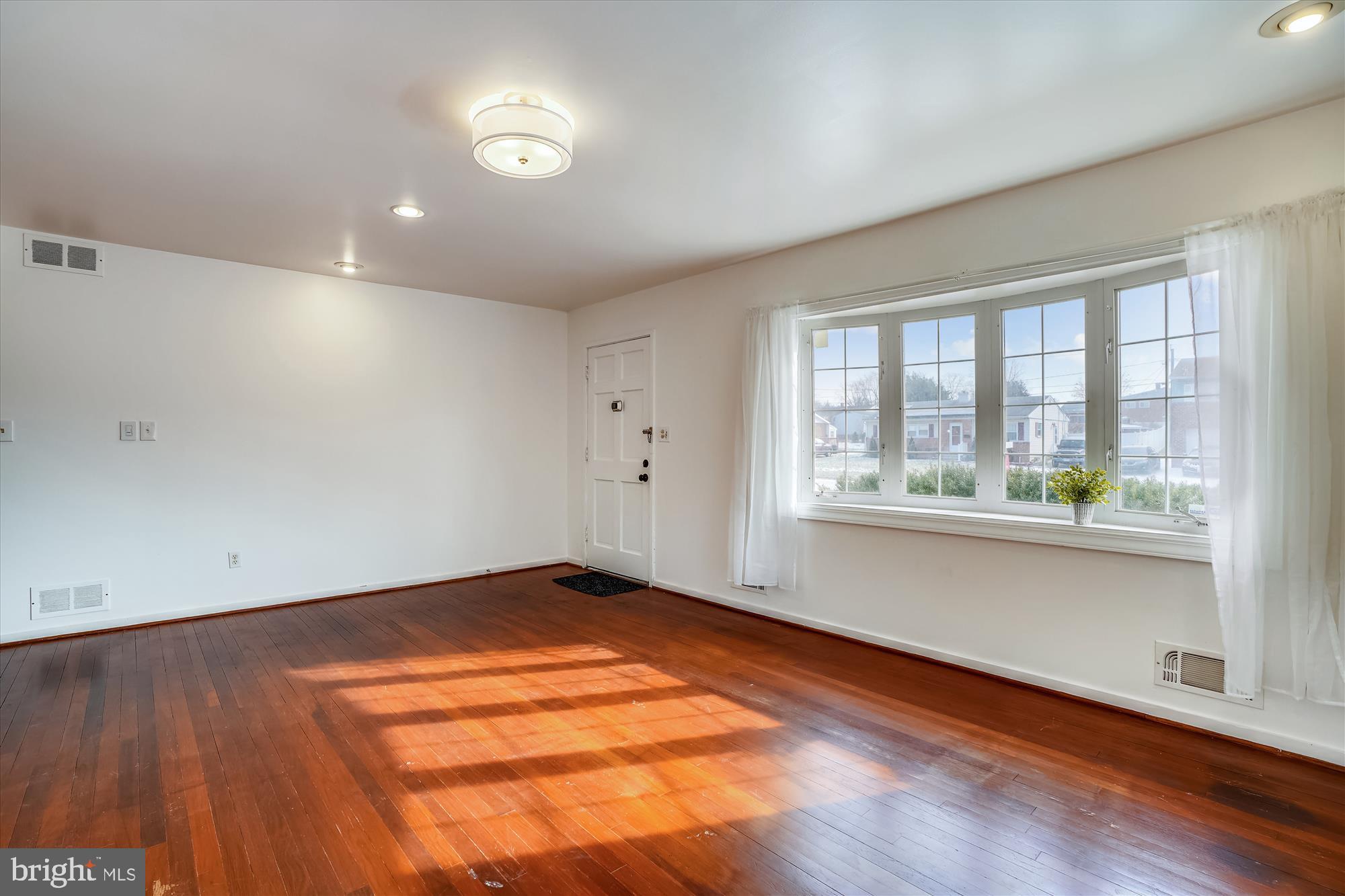 1010 Crosby Road Baltimore, MD 21228 - Photo 6 of 47 an empty room with wooden floor and windows