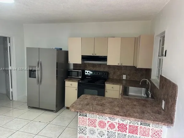 a kitchen with a refrigerator sink and stove