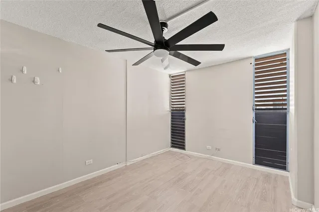 an empty room with closet and a ceiling fan