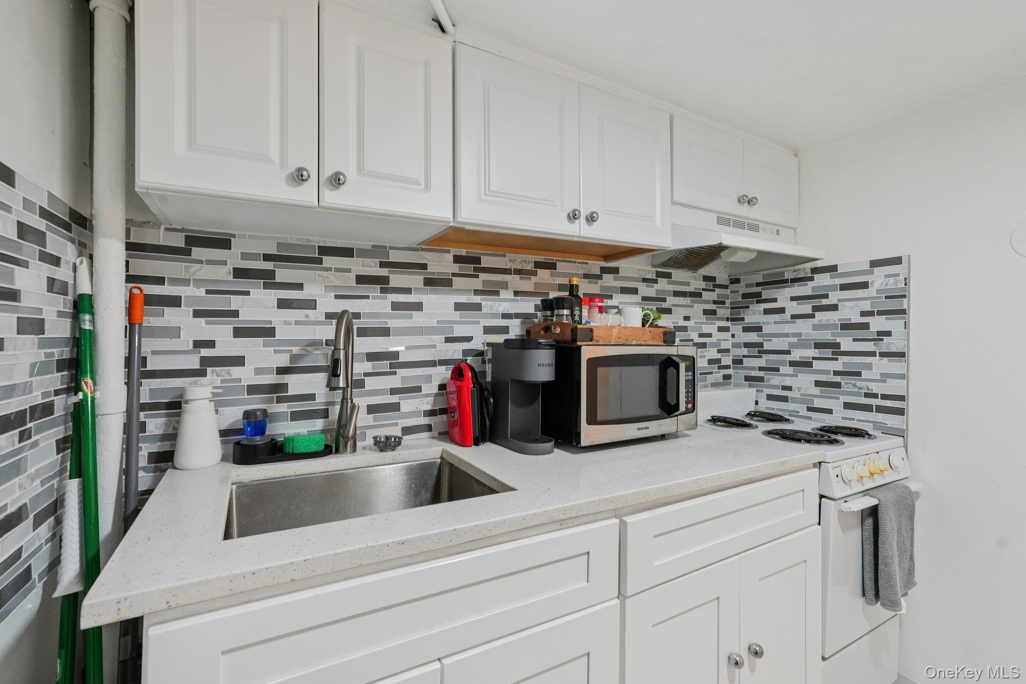 30 Ferdinand Place New Rochelle, NY 10801 - Photo 29 of 46 a kitchen with white cabinets and a stove with a dishwasher