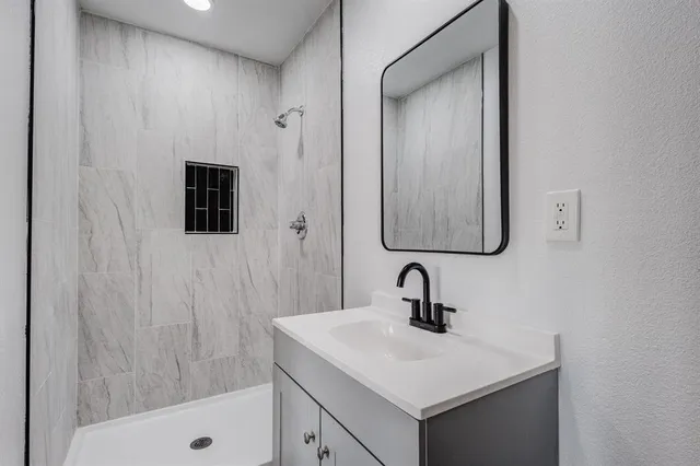 a bathroom with a sink a mirror and shower