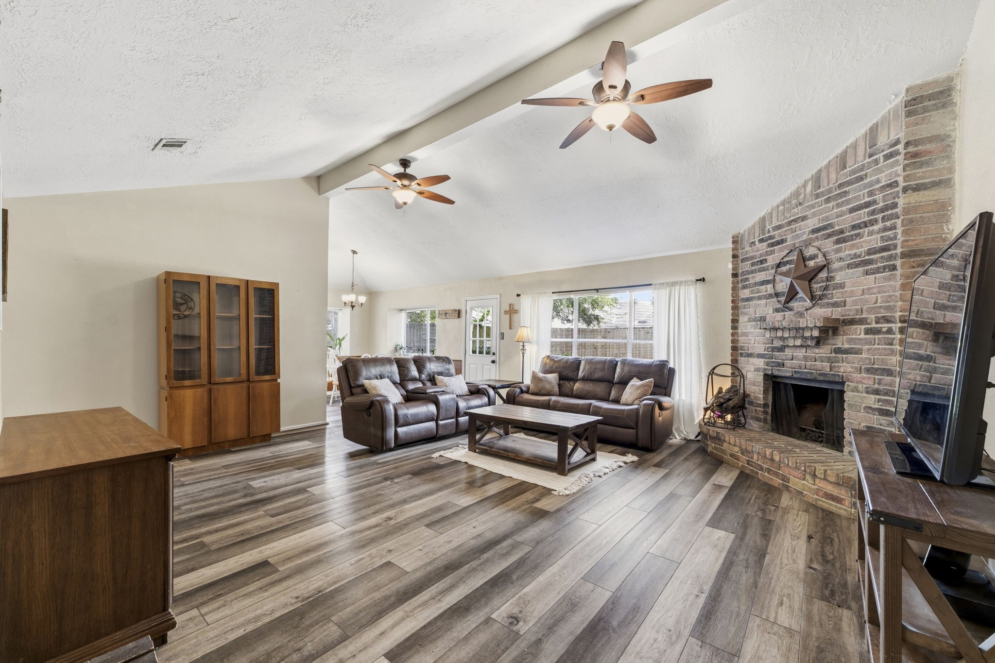 5603 Lynngate Drive Spring, TX 77373 - Photo 7 of 35 Massive family room with vaulted ceilings, vinyl flooring, wood-burning fireplace and wall of windows with view to backyard