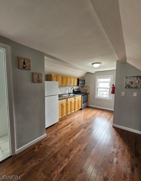 a view of a kitchen with wooden floor and electronic appliances