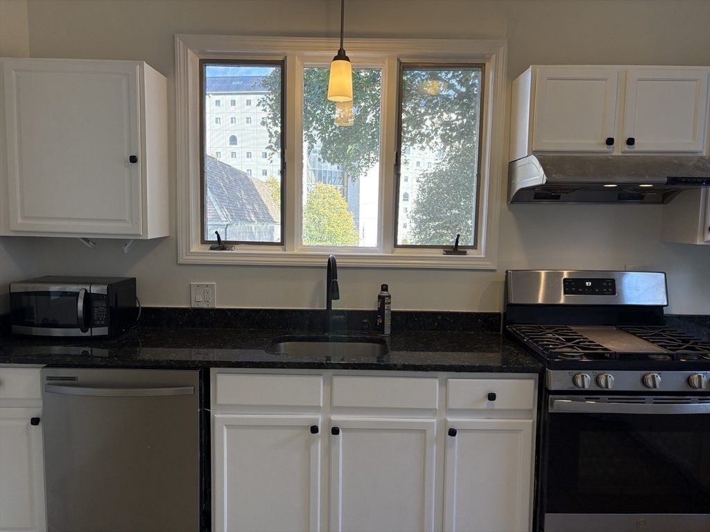 57 Coburn Avenue, Unit 2 Worcester, MA 01604 - Photo 14 of 42 a kitchen with granite countertop a stove a sink and a granite counter tops
