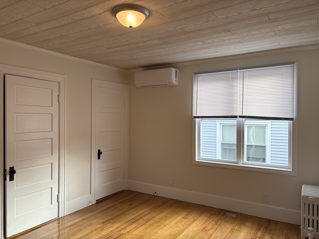 57 Coburn Avenue, Unit 2 Worcester, MA 01604 - Photo 19 of 42 an empty room with wooden floor and windows