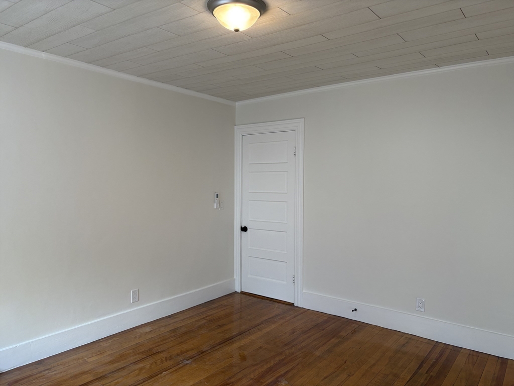 57 Coburn Avenue, Unit 2 Worcester, MA 01604 - Photo 22 of 42 a view of an empty room with wooden floor and windows