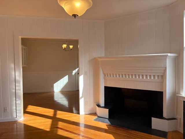 a view of a room with a ceiling fan and wooden floor