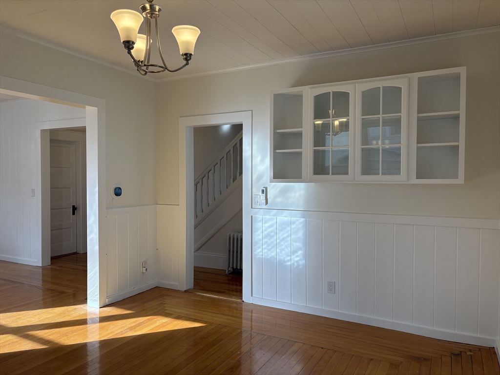 57 Coburn Avenue, Unit 2 Worcester, MA 01604 - Photo 7 of 42 an empty room with wooden floor and chandelier