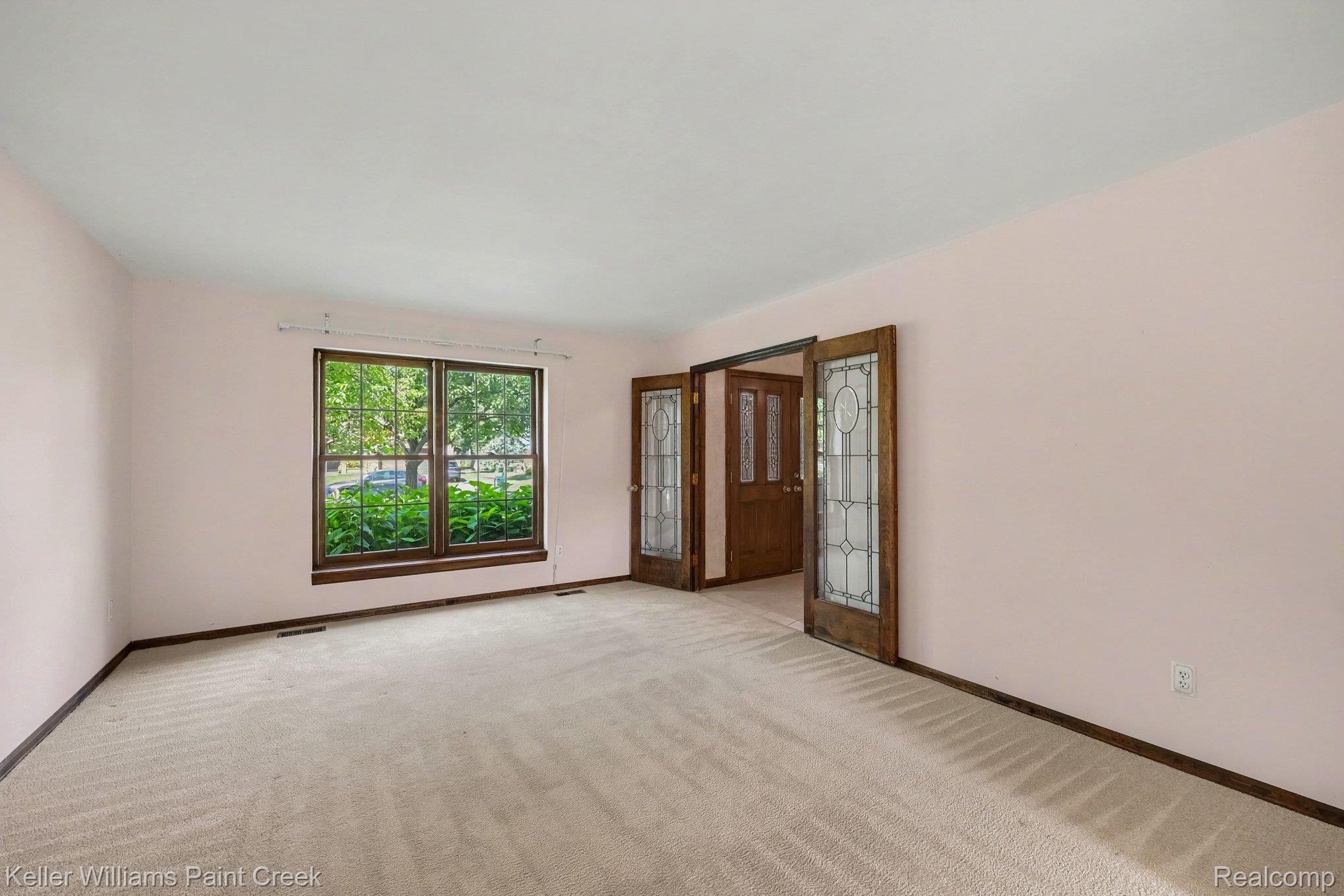 2717 Powderhorn Ridge Road Rochester, MI 48309 - Photo 13 of 48 Two-panel window with dark wood trim, wall-to-wall carpeting, and wood-finish doors with leaded glass panels