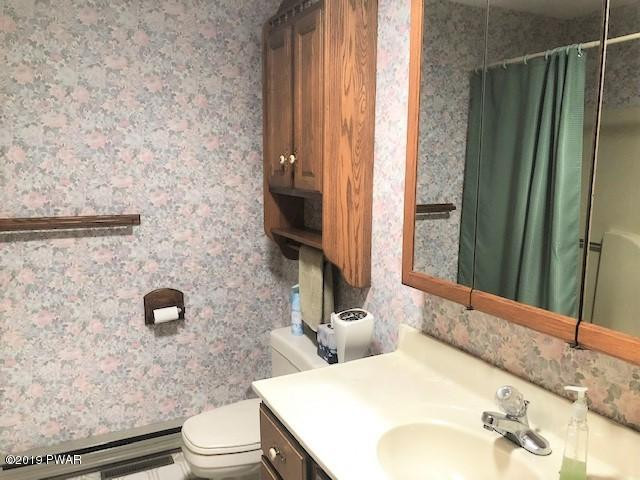 161 Tuthill Road Waymart, PA 18472 - Photo 18 of 31 a bathroom with a granite countertop toilet sink and mirror