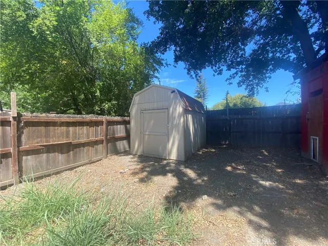 a view of backyard with tree and wooden fence