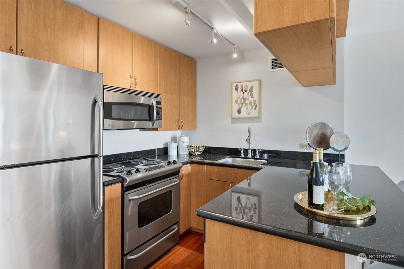 1105 Spring Street, Unit 902 Seattle, WA 98104 - Photo 8 of 21 a kitchen with kitchen island granite countertop a stove and a refrigerator