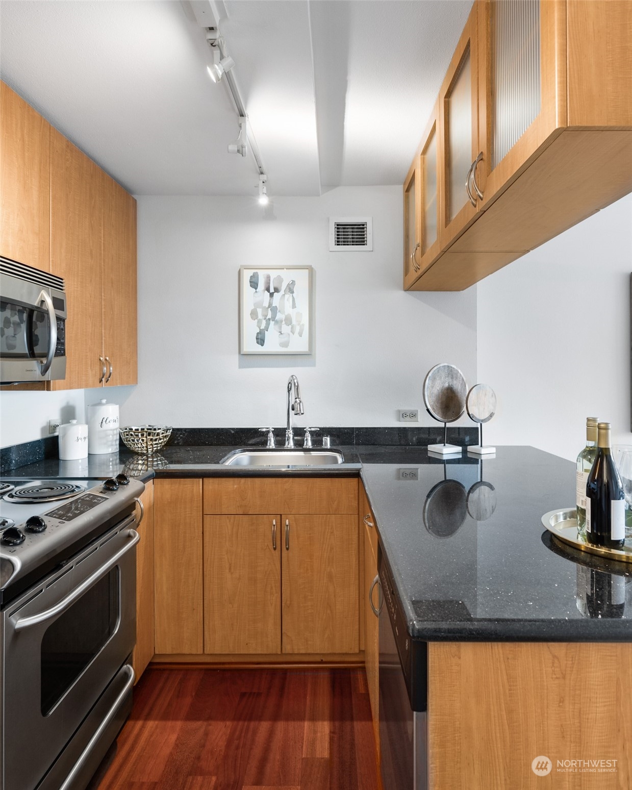 1105 Spring Street, Unit 902 Seattle, WA 98104 - Photo 9 of 21 a kitchen with stainless steel appliances granite countertop a sink stove and cabinets